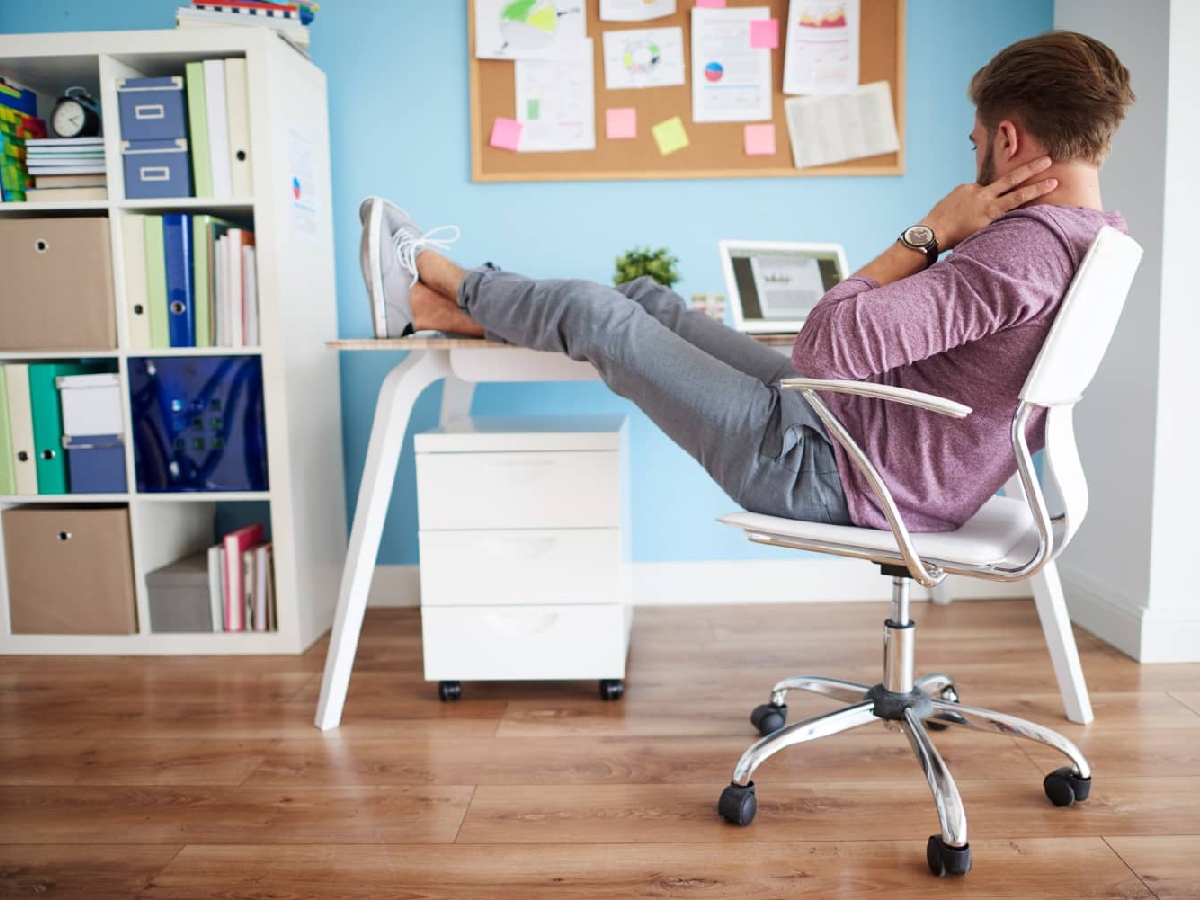 دفتر کار اداری و مردی لم داده روی صندلی