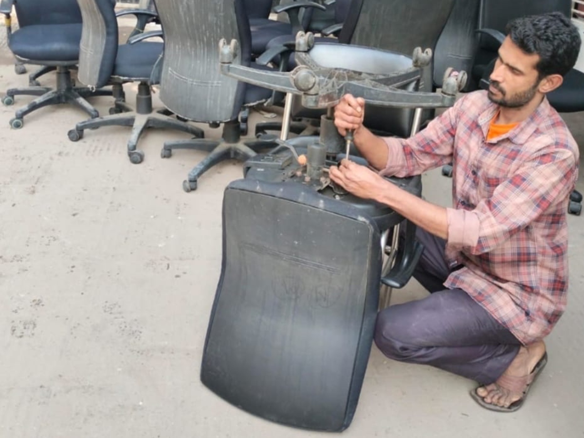 یک کارگر در حال بازسازی صندلی اداری